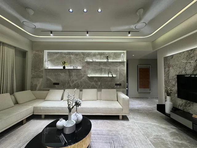 Living room with grey-veined marble flooring and an illuminated marble wall