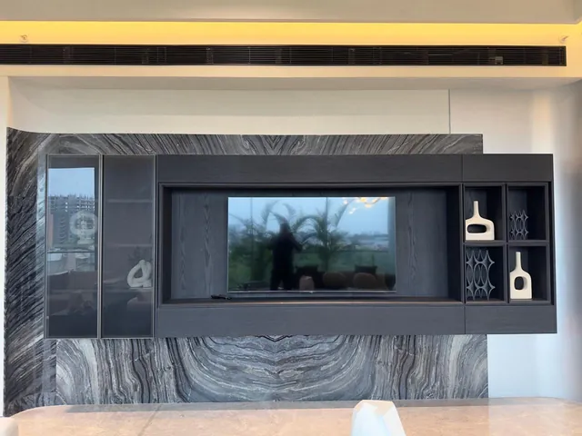 Black-and-white veined marble TV wall in a long living room